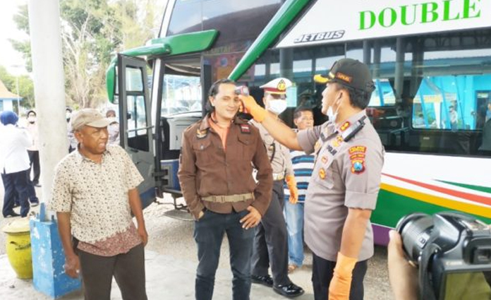 Kapolres Bangkalan, AKBP Rama Samtama Putra, tengah mengecek suhu tubuh dari salah satu penumpang di Terminal Bangkalan pada Selasa (17/3)