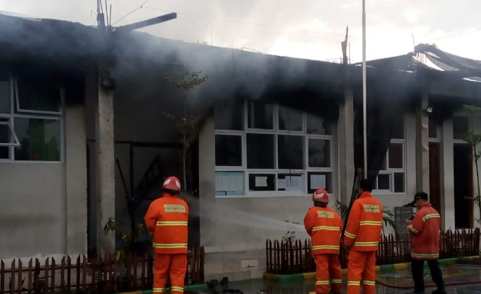 Petugas PMK Gresik tengah berusaha memadamkan api di salah satu ruang kelas MTs Ma'arif Sidomukti 2 Gresik pada Rabu (4/3)