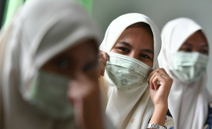 Sejumlah siswa tengah mengenakan masker gratis, yang diberikan oleh Lembaga Falakiyah Pengurus Cabang Nahdlatul Ulama (LF PCNU) Kabupaten Gresik pada Kamis (5/3)